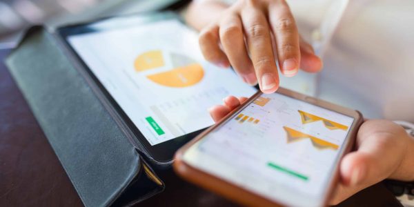 Woman conducting keyword research on a tablet and mobile device.